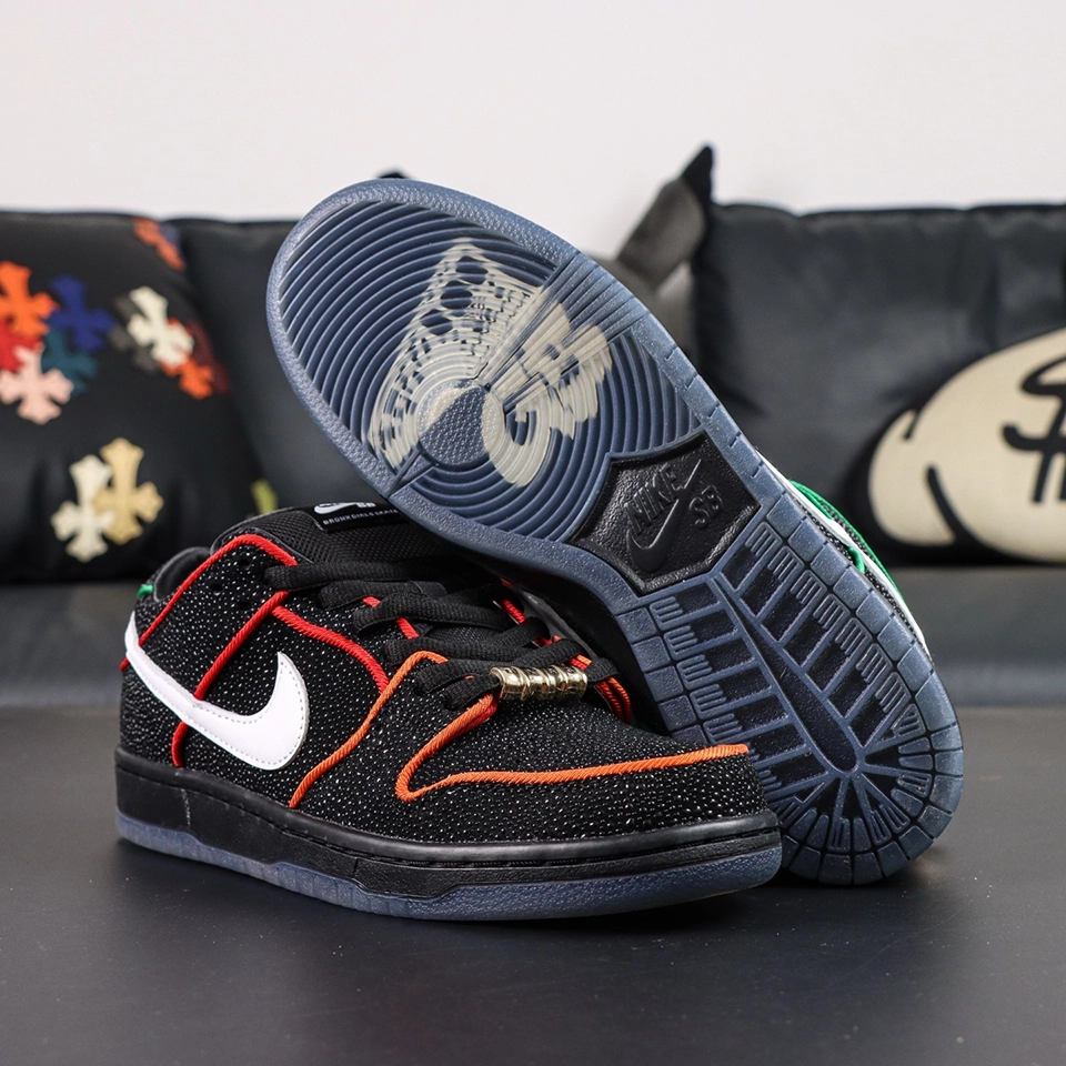 Pair of Bronx Girls Skate x Nike Dunk Low SB ‘Mel & Kava’ with one shoe flipped to show icy blue outsole featuring translucent BXGS graphic