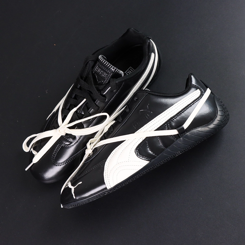Rosé x Wmns Speedcat Premium ‘Black’ top-down view highlighting dual-lace setup with classic black laces and diagonal off-white secondary laces.