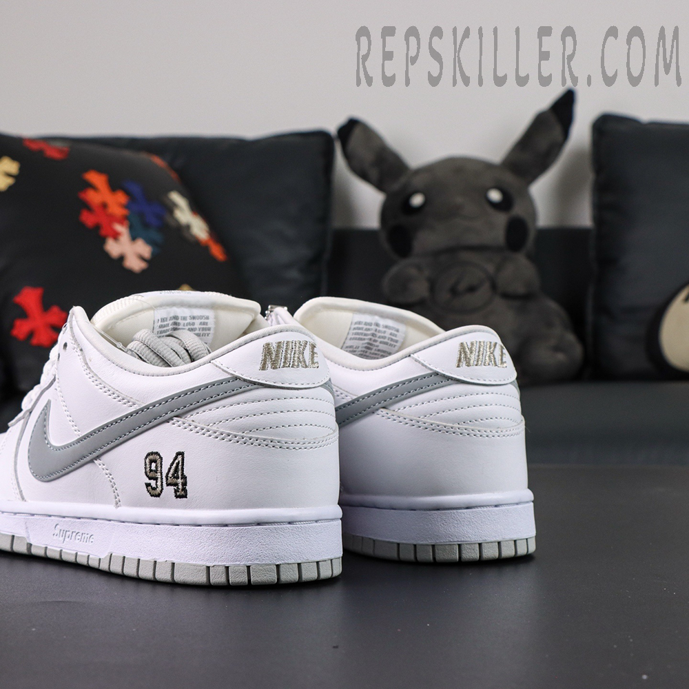 Nike Supreme x Dunk Low SB “White Metallic Silver” angled back view featuring silver swoosh and 94 embroidery on the heel.