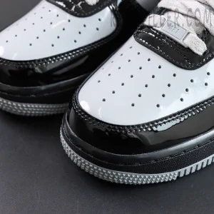 Toe box detail with perforations and patent leather overlays