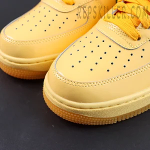 Nike Air Force 1 Low “Patent Leather Topaz Gold” toe box close-up featuring glossy yellow leather and classic perforated ventilation details