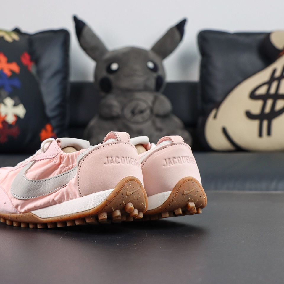 Jacquemus x Nike Moon Shoe SP “Aluminum Pink” angled heel view highlighting pink suede heel panels and speckled retro outsole construction