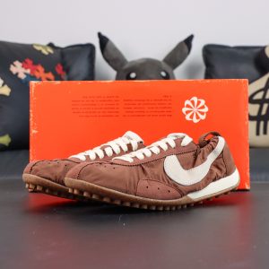 Jacquemus x Nike Moon Shoe SP “Fauna Brown” displayed with vintage-inspired orange packaging and collaborative branding details