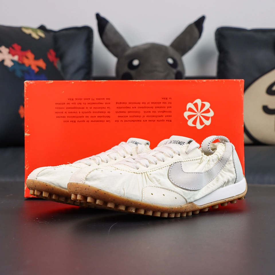 Jacquemus x Nike Moon Shoe SP “Soft Pearl” displayed with a vintage orange Nike shoe box highlighting the collaborative retro aesthetic