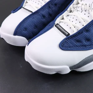 Air Jordan 13 Retro “Flint” toe box close-up featuring smooth white leather with navy textile overlays