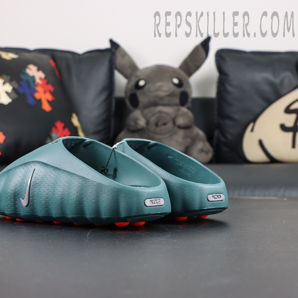 Nike Mind 001 “Mineral Slate” rear view featuring a mineral green foam upper with silver Swoosh branding and orange outsole pods