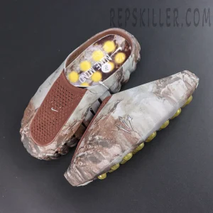 Drake NOCTA x Nike Mind 001 Bronze slip-on shoes top view featuring a brown camouflage upper with yellow cushioning pods