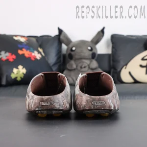Drake NOCTA x Nike Mind 001 Bronze heel detail featuring the metallic Nike badge and camouflage upper design