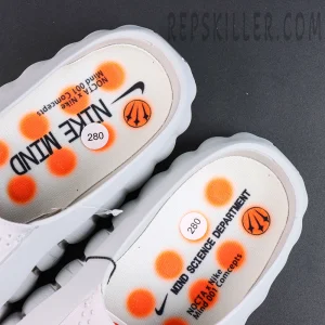 Drake NOCTA x Nike Mind 001 ‘Light Grey’ insole detail featuring NOCTA x Nike Mind branding with orange graphic accents for a unique collaborative design