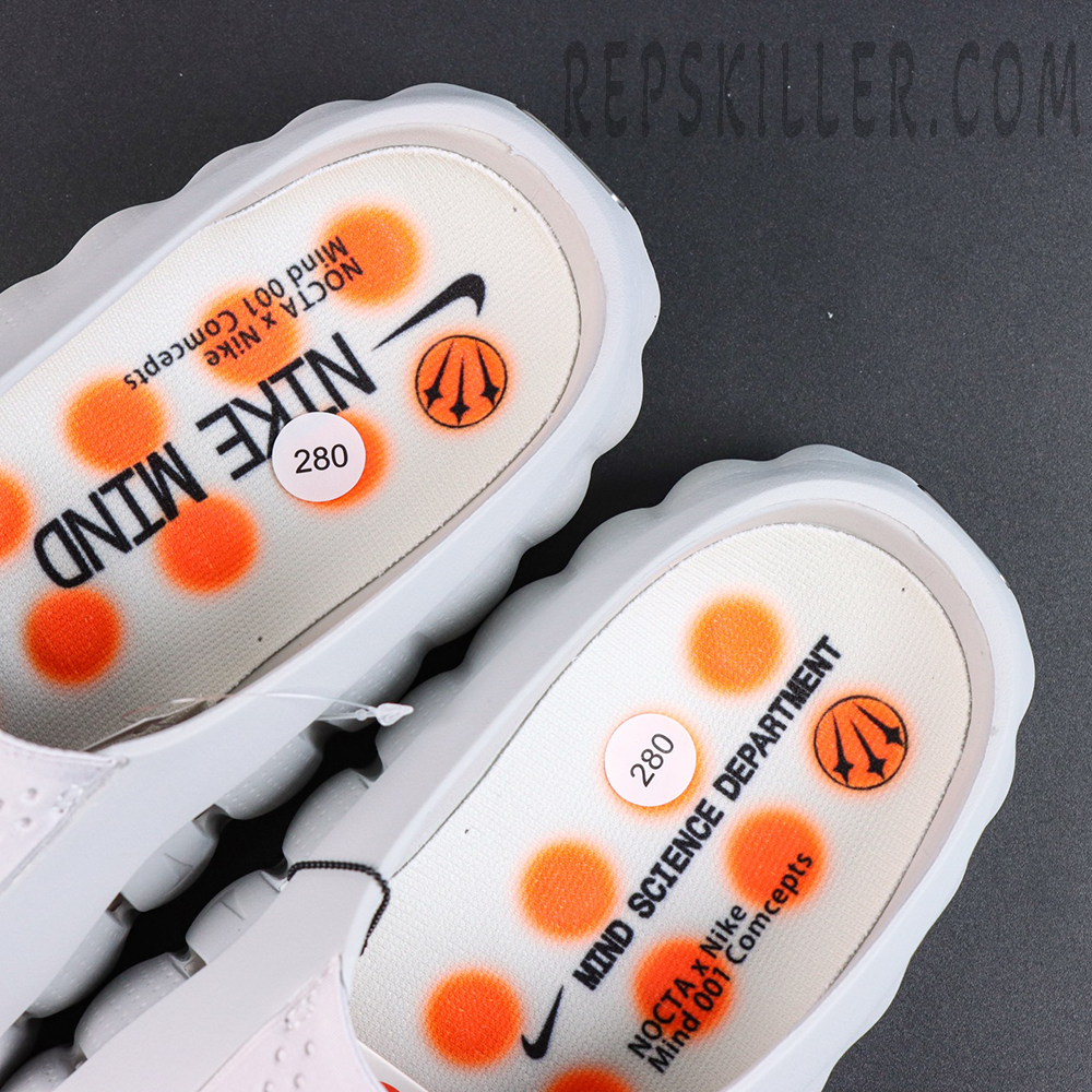 Drake NOCTA x Nike Mind 001 ‘Light Grey’ insole detail featuring NOCTA x Nike Mind branding with orange graphic accents for a unique collaborative design