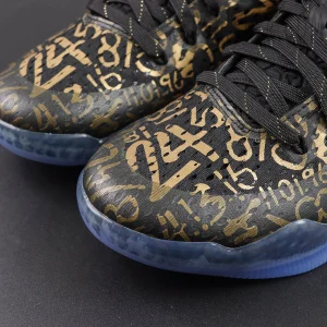 Kobe 11 Protro Low ‘Mamba Day’ upper detail featuring black base with metallic gold numbers and tribute graphics