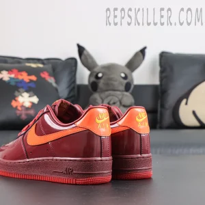 Nike Air Force 1 Low ‘Patent Leather Dark Team Red’ heel view featuring dark red patent leather, orange heel tabs and embroidered Nike Air branding