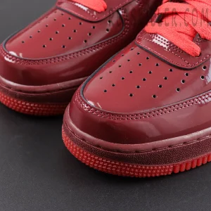 Nike Air Force 1 Low ‘Patent Leather Dark Team Red’ toe close-up featuring a dark team red patent leather upper, perforated detailing and red rubber outsole